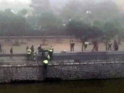 Los servicios de emergencia tratan de rescatar a uno de los ultras arrojados al r&iacute;o.