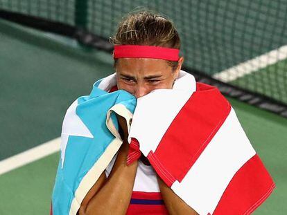 Puig celebra su triunfo envuelta en una bandera de su pa&iacute;s.