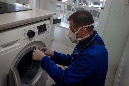 Un técnico repara una lavadora durante el confinamiento.