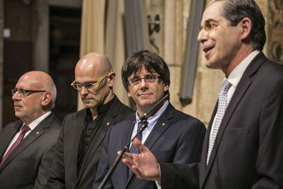 Carles Puigdemont, durante el acto, entre Ra&uuml;l Romeva (i) y el c&oacute;nsul Juan Alberto Buffa