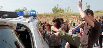 Un grupo de estudiantes golpea el coche de la Policía Municipal de Madrid, durante los incidentes por una jornada sobre colaboración entre España e Israel en materia de Energías Renovables.