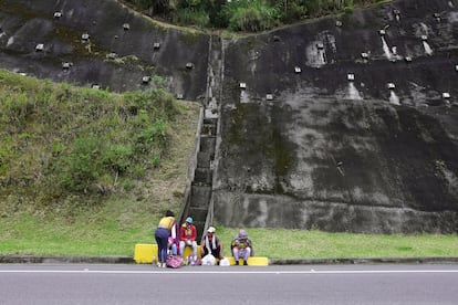 Migrantes venezolanos hablan al costado de una carretera colombiana, luego de que el Gobierno de este país reactivara los sectores económicos al final de la cuarentena.