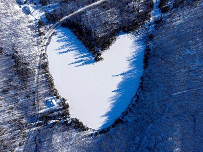La nieve cubre el estanque Baker, en forma de corazón y congelado en la víspera de Navidad, en East Bolton, Canadá.