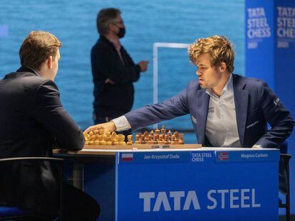 Carlsen pone en marcha el reloj de Duda al inicio de la partida de hoy; al fondo, el director del torneo, Jeroen Van den Berg