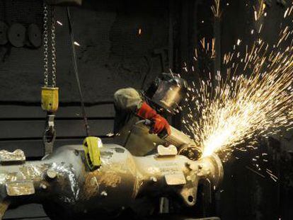 Un trabajador pule uno de los ejes para Caterpillar fabricados de una pieza en acero carbono en las instalaciones de Novacero en Vitoria.