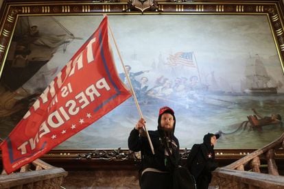 Un hombre lleva una bandera de apoyo a Trump durante el asalto al Capitolio en Washington, el 6 de enero.