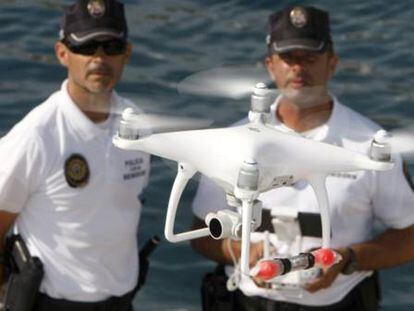 Agentes de la Policía Local de Benidorm con el dron que sirve para vigilar el litoral.