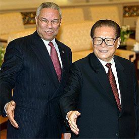 Collin Powell y Jiang Zemin sonríen ante las cámaras comentos antes de su reunión, hoy en Pekín.