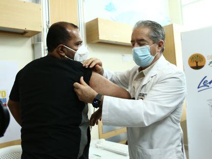 El ministro de Salud de Ecuador, Juan Carlos Zevallos, explica con un voluntario el proceso de vacunación contra la covid-19, el 21 de enero en Guayaquil, Ecuador.