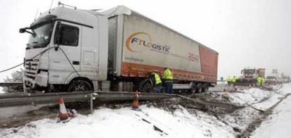 Los operarios retiran un camion que ha quedado cruzado en la autoviaA-2 a la altura de Frasno