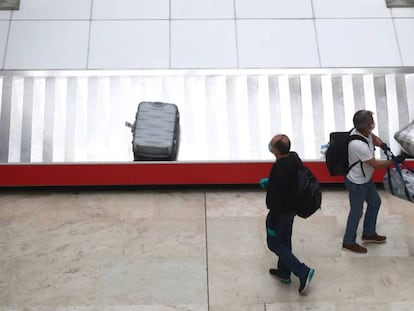 Dos pasajeros recogen su equipaje ayer, 12 de mayo, en el aeropuerto de Madrid-Barajas.