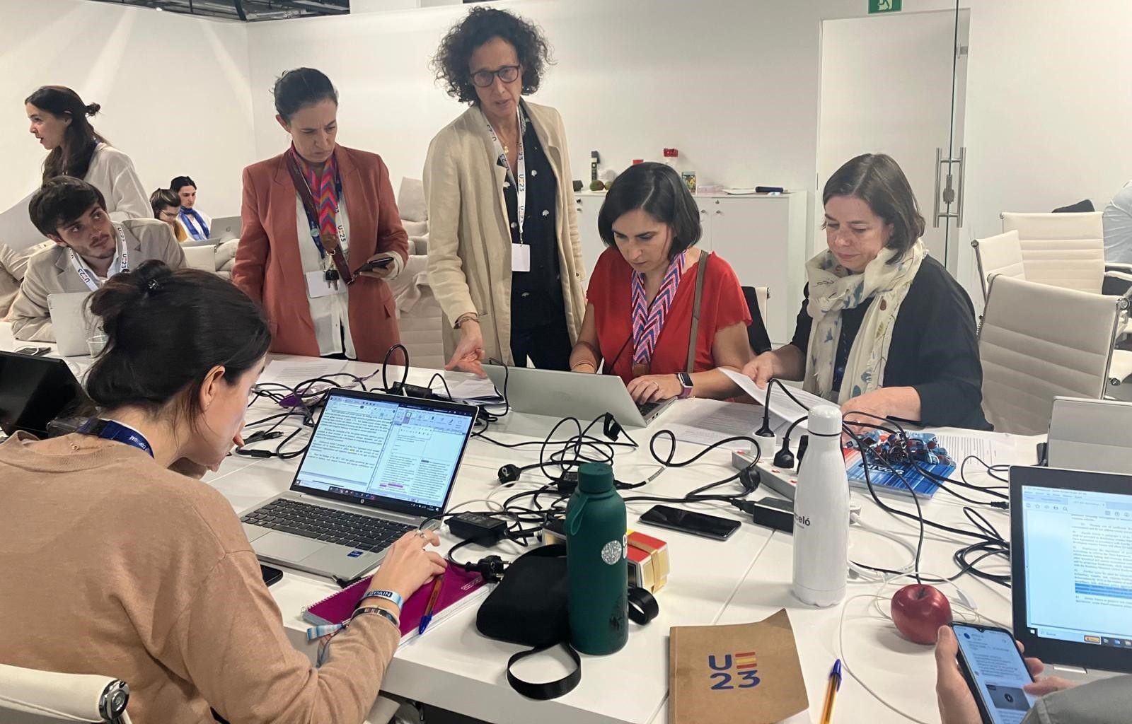 Valvanera Ulargui (en el centro y de pie) con algunos miembros de la Oficina Española de Cambio Climático, analizando el primer texto de la presidencia de la COP28. / MITECO