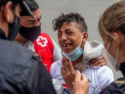 Varios agentes y voluntarios de Cruz Roja atienden a un menor en Ceuta.