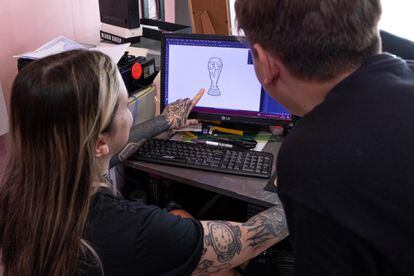 Emily Lago enseña a uno de los clientes de Coven Studio un diseño de la Copa del Mundo.