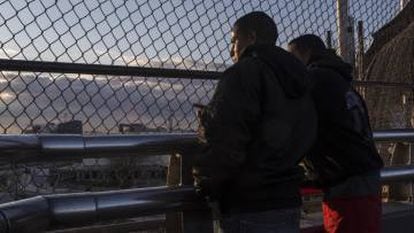 Ángel y David Castillo miran Estados Unidos a través del puente fronterizo.