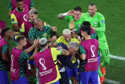 The Brazilian players celebrate with their coach Tite the third goal of the game scored by Richarlison.  