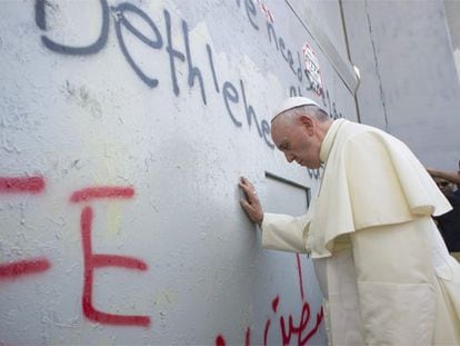 El Papa toca el muro que separa Israel de Cisjordania.