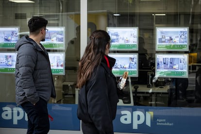 Dos viandantes miran el escaparate de una inmobiliaria en Barcelona, esta semama.