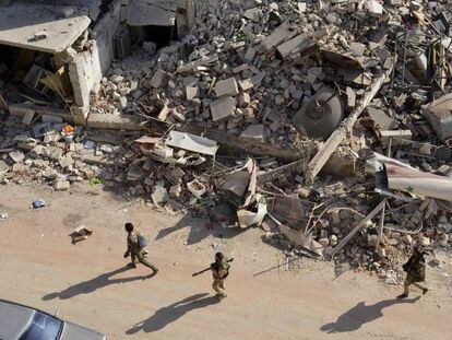 Soldados sirios entre los escombros en el oeste de Alepo.
