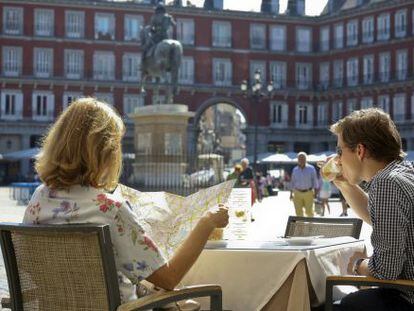 Una pareja de turistas, en una terraza de la plaza Mayor.