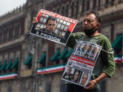 Un ciudadano sostiene imágenes de ex presidentes frente al Palacio Nacional durante la recolección de firmas para enjuiciarlos.