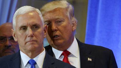 Donal Trump, en segundo plano, habla con Mike Pence