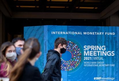 Varios jóvenes pasan ante la sede del FMI en Washington, este lunes.