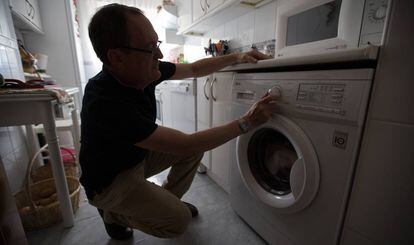 Un hombre pone una lavadora en su domicilio.