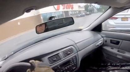 Captura de video que muestra a un hombre, que luego del tiroteo llega al estacionamiento del supermercado TOPS, con lo que parecen ser armas apoyadas en el asiento del pasajero. El sujeto fue detenido por la policía. 