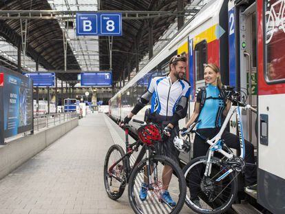 Dos ciclistas suben a un tren de SBB, la red de ferrocarriles de Suiza, uno de los paraísos del cicloturismo.