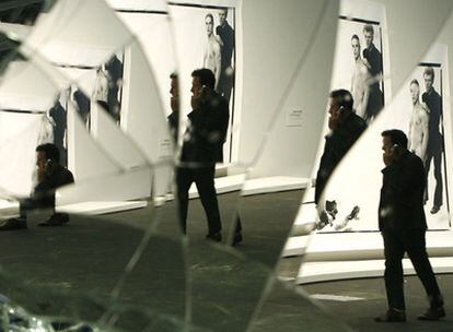 Un visitante se refleja en la obra <i>Mirror Wall</i>, de Banks Violette, mientras pasa ante fotografías de Richard Avedon en la feria Art Basel de 2008.