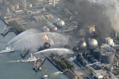 Varios barcos intentan apagar un incendio desatado en una refinería de petróleo en Sendai.