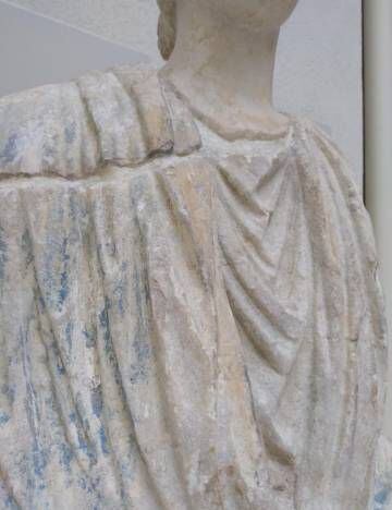 Detalle de la fractura entre el busto y el cuerpo y de los restos de policromía en la escultura.