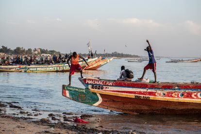 Muchachos merodeando por las embarcaciones que los migrantes utilizan para salir hacia Canarias desde Mbour, en Senegal. / SYLVAIN CHERKAOUI 