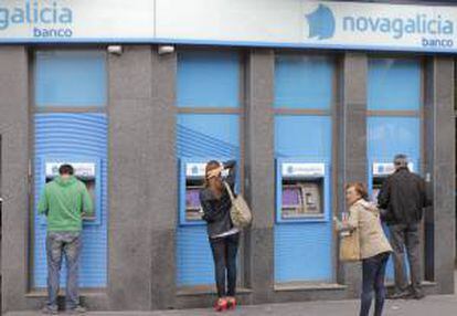 Usuarios de los cajeros en una sucursal de Novagalicia Banco, en Santiago de Comspotela. EFE/Archivo