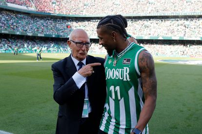 Antonio Zapata, delegado de campo del Real Betis de Baloncesto, junto a la estrella del equipo Shannon Evans, en el césped del Benito Villamarín.