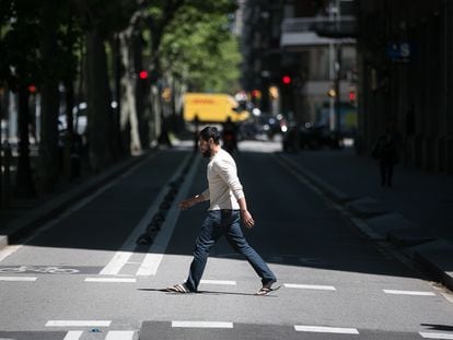 Un hombre cruza el carril lateral de la Gran Via de Barcelona, donde se cortará el tráfico para dar espacio a los peatones.