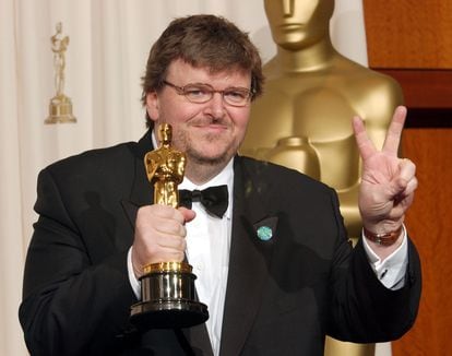 Michael Moore sostiene su Oscar haciendo el símbolo de la victoria.