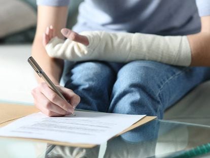 Una mujer rellena un formulario en un hospital.