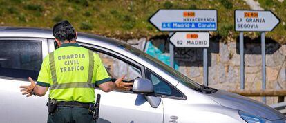 Miembros de la Guardia Civil realizan controles a los conductores en la carretera que da acceso a Navacerrada y Cotos, en Madrid. 