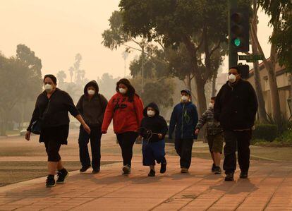 Una familia camina por las calles de Ventura, California, tras el incendio que arrasó con cientos de hogares y obligó a cientos de miles evacuar la zona.