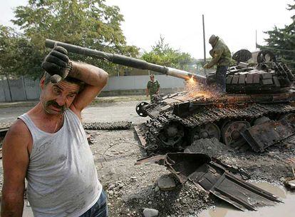 Un trabajador corta con un soplete el cañón de un tanque georgiano destrozado durante los enfrentamientos de este mes en Osetia del Sur.