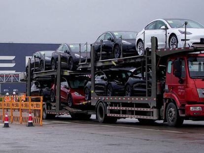 Un camión transporta coches nuevos de Tesla frente a la fábrica de la compañía en Shanghái, China.