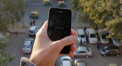 Un usuario de Uber muestra la aplicación en su 'smartphone'.