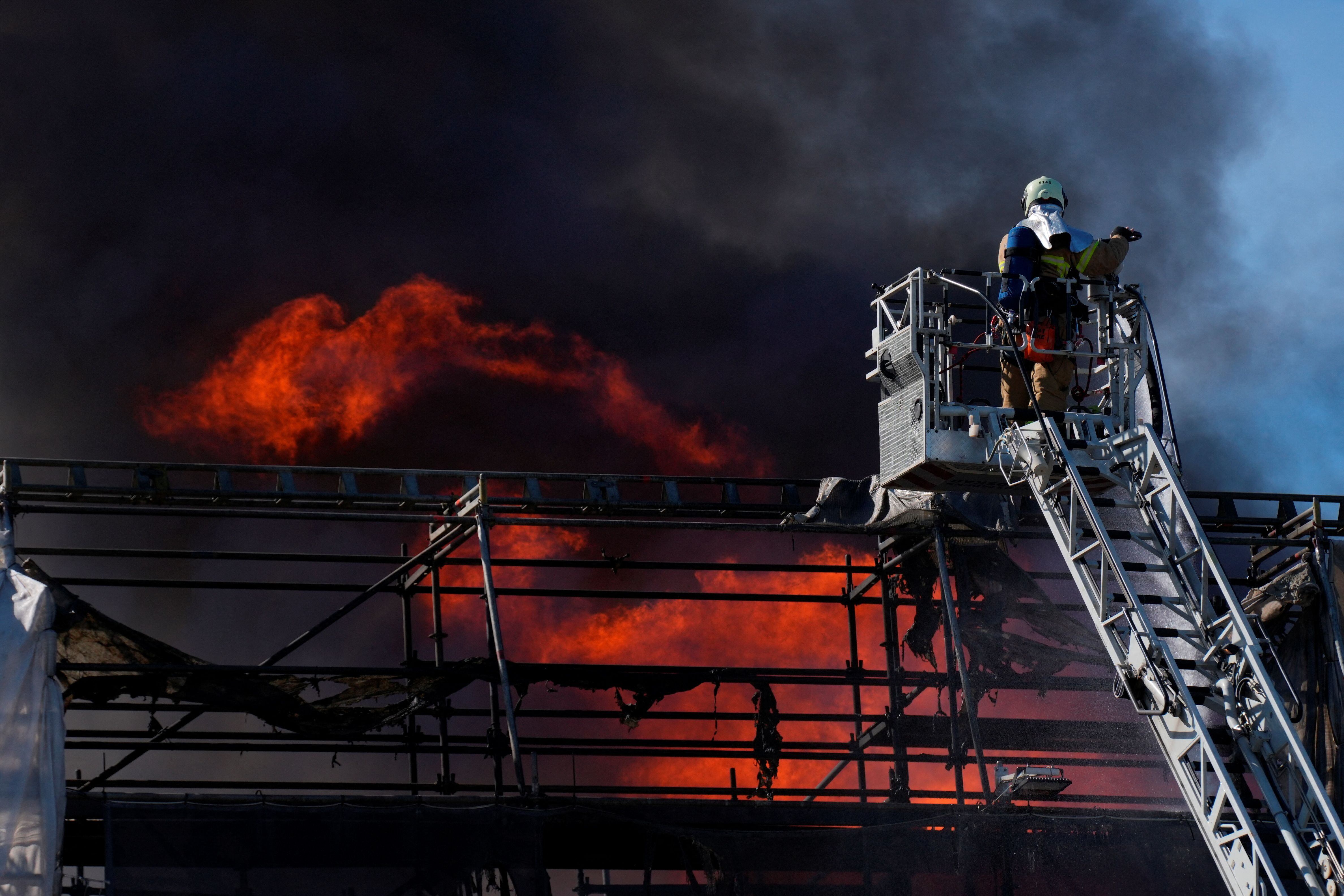 Un bombero apaga las llamas del edificio de la Bolsa de Copenhague, este martes.  