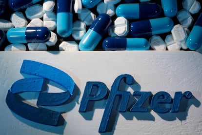 Logo de Pfizer impreso en 3d junto a píldoras fabricadas por el laboratorio