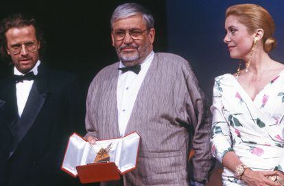 Maurice Pialat con Catherine Deneuve a su izquierda y Chistophe Lambert a su derecha muestra la Palma de Oro recibida por 'Bajo el sol de Satán' en Cannes en 1987.
