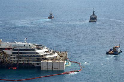 El Costa Concordia, el crucero siniestrado en 2012 frente a la isla italiana del Giglio (centro) y que causó la muerte de 32 personas, comenzó a ser reflotado.