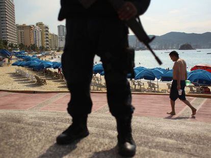 Un polic&iacute;a federal mexicano monta guardia cerca de una playa de Acapulco.