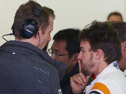 Fernando Alonso, conversa con sus mec&aacute;nicos en el box.